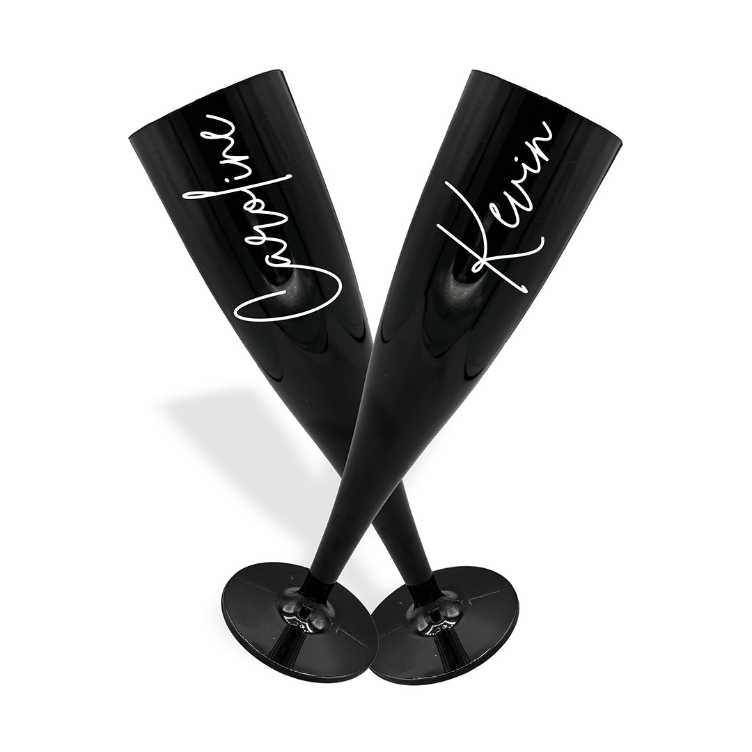 Pair of black plastic champagne flutes in a cross formation, personalised in a pink signature font