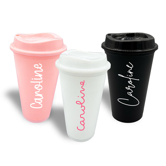 Group of three plastic travel cups with lids in white, pink and black. All personalised with the name Caroline