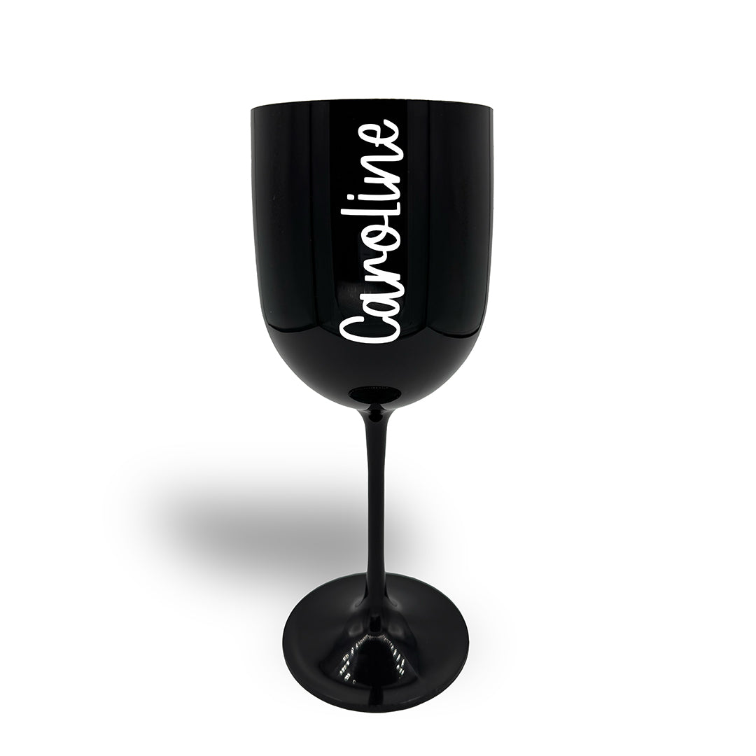 Large black plastic wine glass decorated in white text with the name Caroline in a chunky font