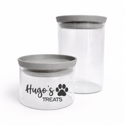 Two clear pet treat jars with gray lids on a white background
