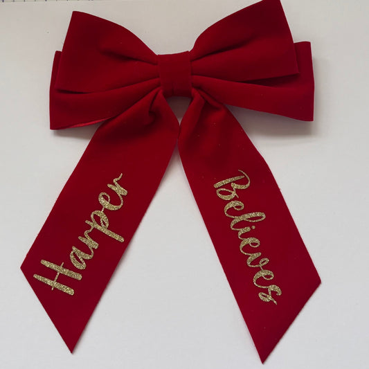 Red bow with gold text on a white background