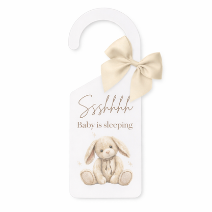 Door hanger with a bunny illustration and text 'Sshhh Baby is sleeping' on a white background