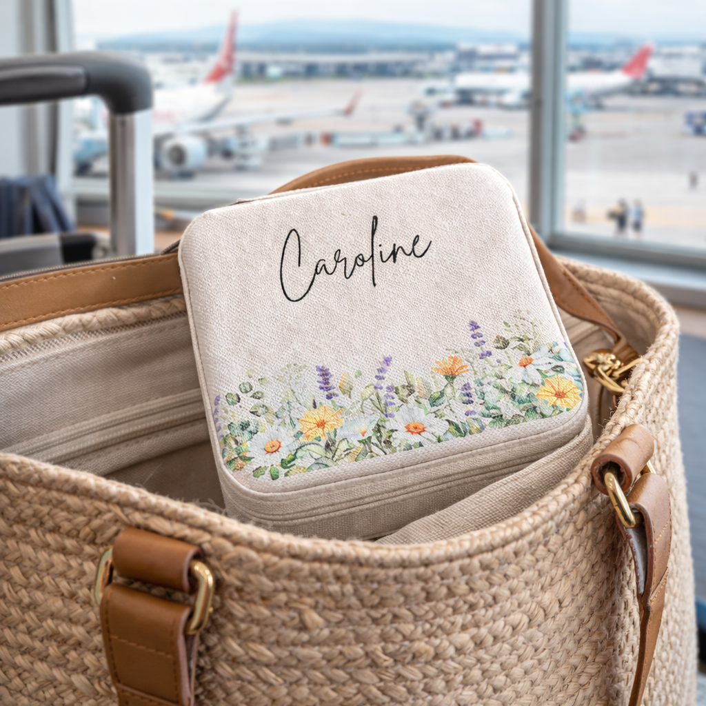 Floral embroidered square in a woven bag with 'Caroline' at an airport.