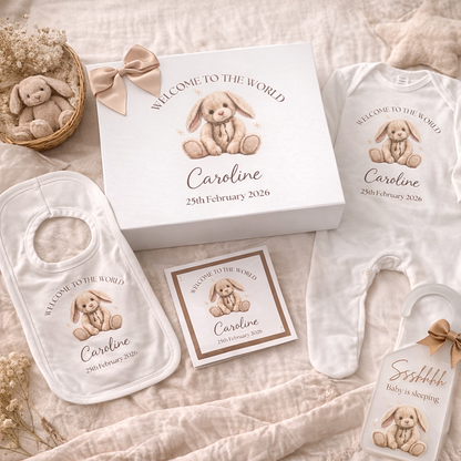 Baby gift set with personalized items on a soft surface