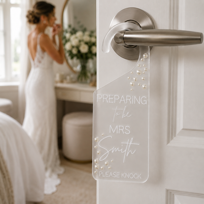 Door with 'Preparing to be Mrs. Smith' sign, bride in background