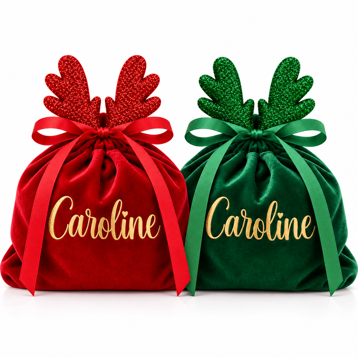 Two personalized Christmas drawstring gift bags in red and green velvet with glittery antler toppers and gold 'Caroline' script, shown on a white background.