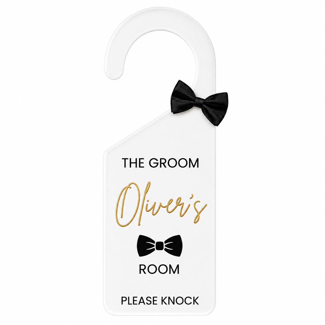 A white personalized hotel door hanger sign with a black bow-tie graphic and text reading 'THE GROOM Oliver's ROOM PLEASE KNOCK' on a plain white background.