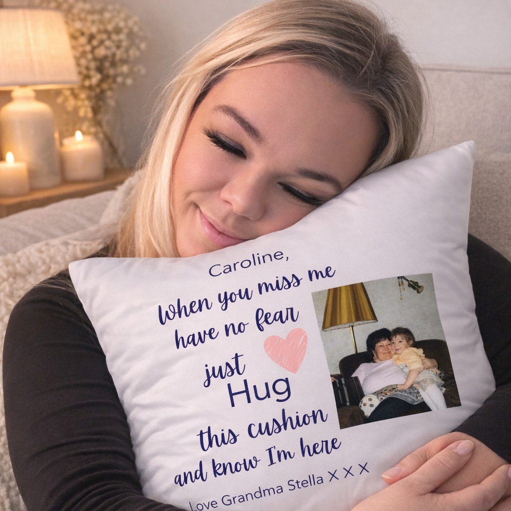 Woman hugging a personalized pillow with a message and photo on it.