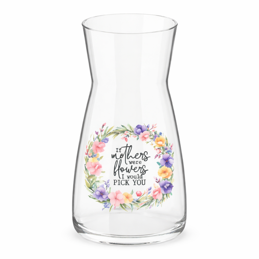 Clear glass carafe with floral design and text on a white background