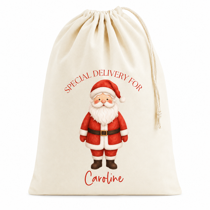 An off-white canvas Christmas stocking bag with a drawstring closure, featuring a printed illustration of Santa Claus and the text 'SPECIAL DELIVERY FOR' and 'Caroline'.
