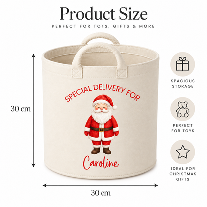 A cream canvas storage basket with a Santa Claus illustration and the text 'SPECIAL DELIVERY FOR Caroline' on the front, shown with dimension arrows indicating 30 cm height and 30 cm width. The image includes product size text at the top and feature icons on the right.