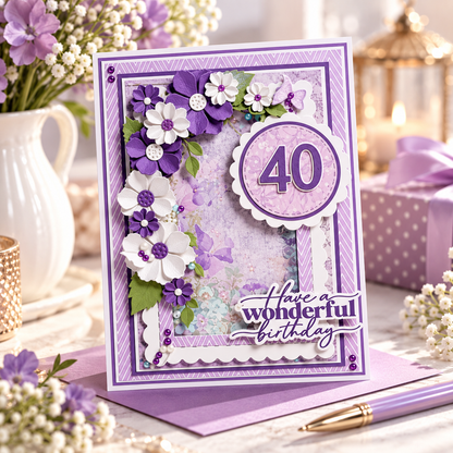 A handmade 40th birthday card with purple and white floral embellishments, a scalloped '40' circle, and the phrase 'Have a wonderful birthday' in script. The card is displayed on a purple surface with a matching pen, surrounded by flowers, a candle, and a gift box in a styled setting.